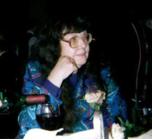 middle-aged woman with glasses and dark hair seated at dinner table