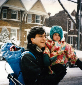 man holding baby on snowy street