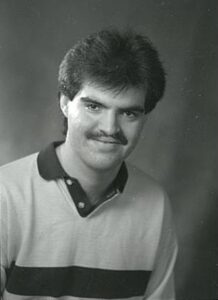 Photo en noir et blanc d'un jeune homme souriant