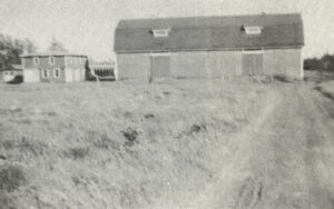 Ancienne photo en noir et blanc d'une grange et d'un champ