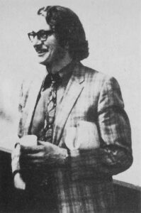 Man with mustache, glasses and 1970s style suit and tie 