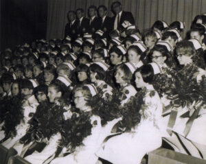 Photo de graduation d'infirmières des années 1960 tenant des bouquets de fleurs