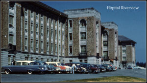 Façade imposante d’un bâtiment institutionnel en brique, avec des voitures des années 1950 stationnées devant