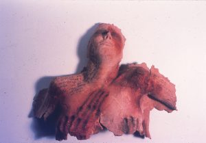 photo of red woman's sculpture head thrown back and shoulders which look burned with messages written on them