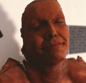 photo of red woman sculpture, face and shoulders and UNLADYLIKE stamped across chest