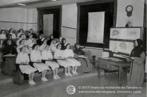 old black and white photograph of uniformed nurses in classroom being instructed by nun in front of room