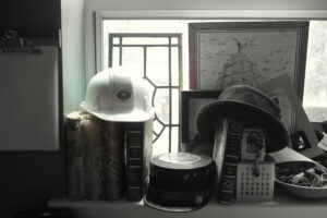 photo of assorted hats, books, art on office window sill