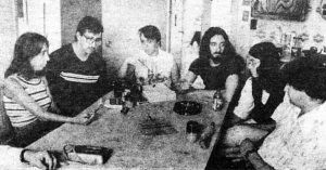 group of 1970s young people sitting around a table