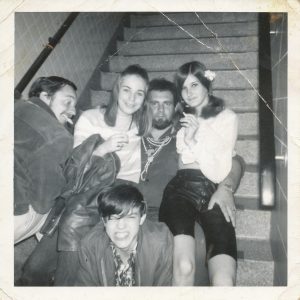 2 young girls, one young boy and 2 older young men sitting on stairs