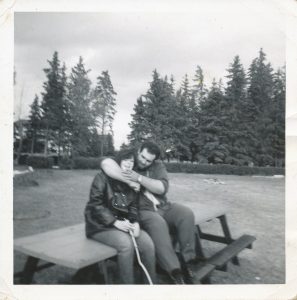 young woman and man sitting on picnic bench on playing field