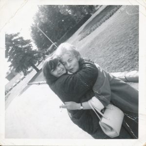 young woman and old woman hugging, 1960s style clothing