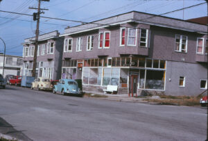 older corner store front with cars parked in front