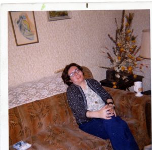 woman with glasses and dark hair sitting on couch