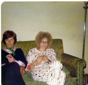 two women in night dresses sitting on a couch