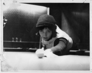 young woman in hat playing pool