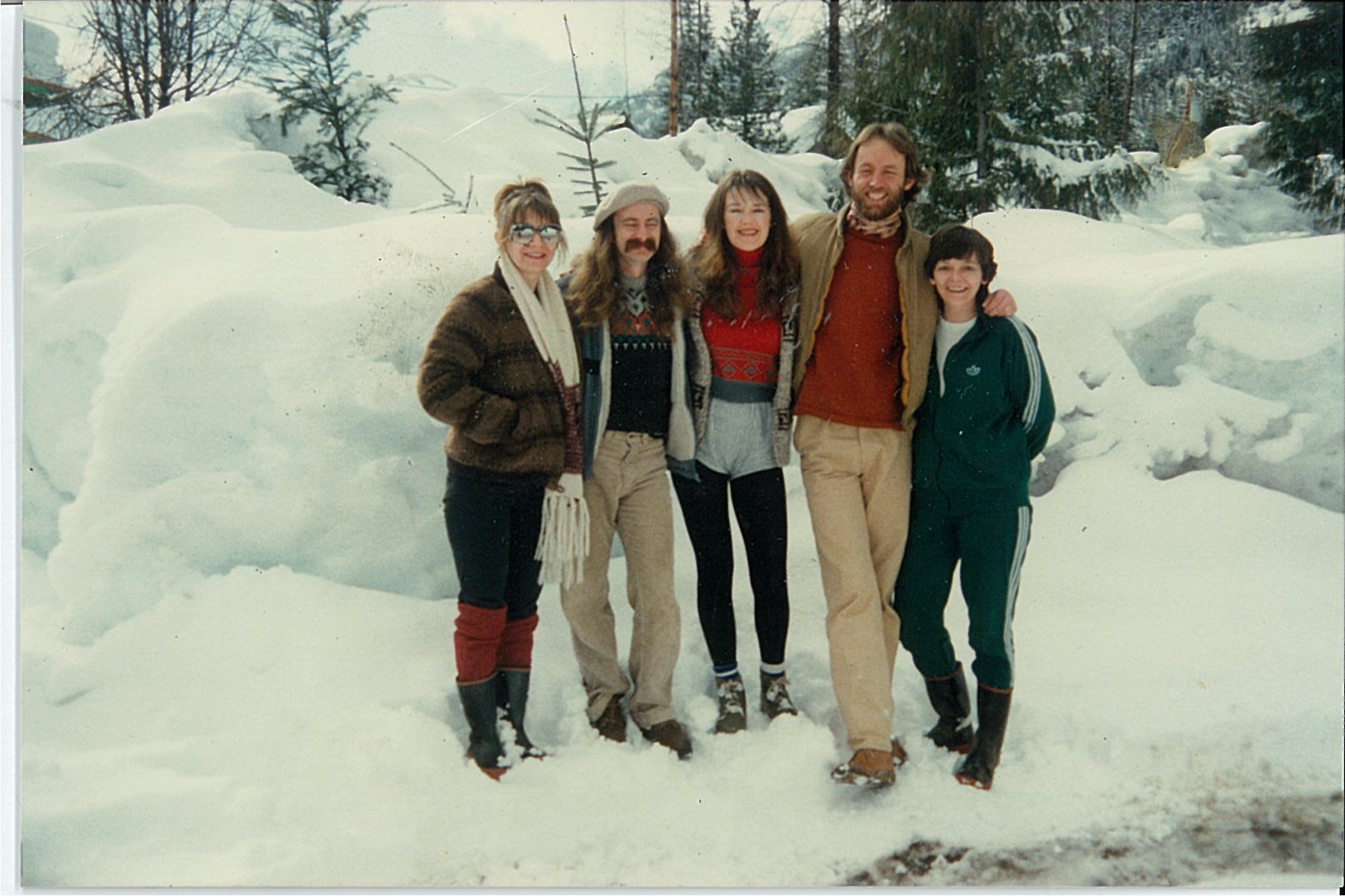 5 people standing in a row in the snow wearing winter clothes