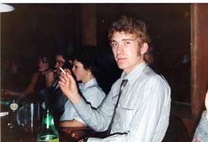 man with blond curly hair seated at dinner table