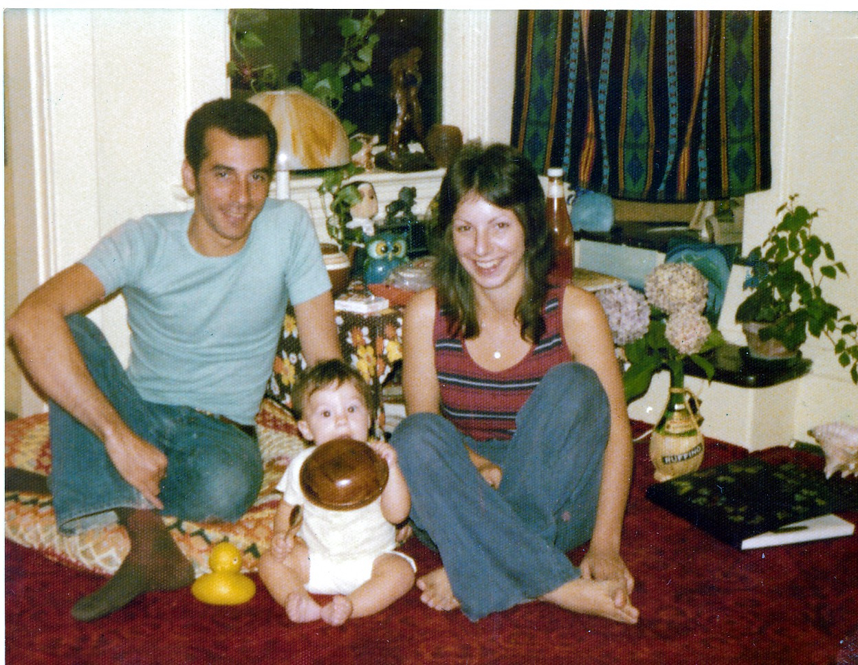 dark haired man, baby, woman sitting on floor